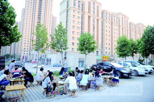 中建凤栖第小区北边的小吃摊异常红火,不少食客在路边就餐