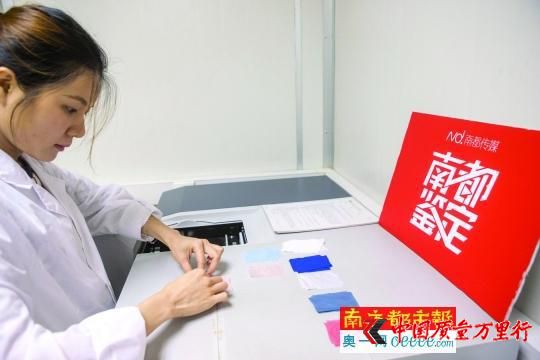 实验员将防晒服的布料样品放入紫外可见分光光度计进行检测。